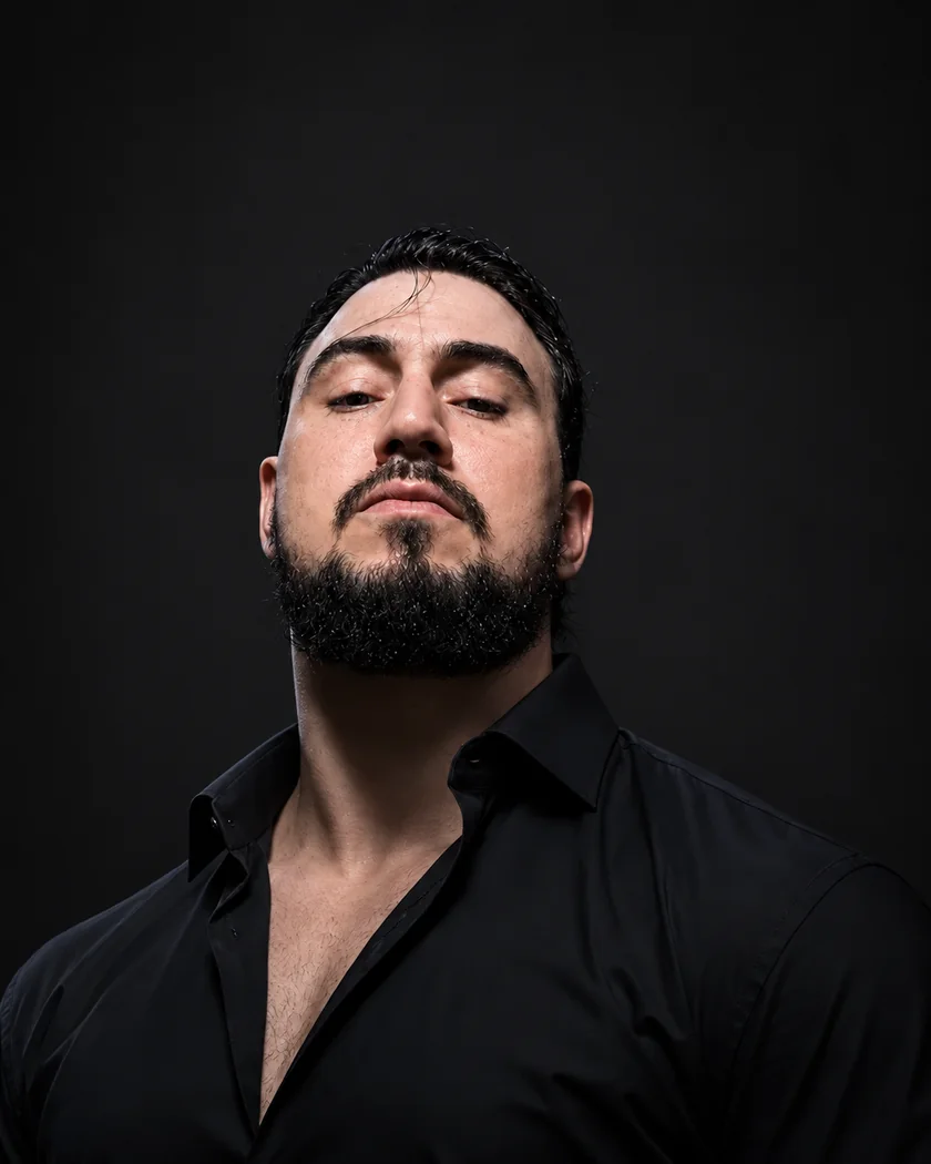 Retrato de Yuri Queiroz de camisa preta em fundo escuro